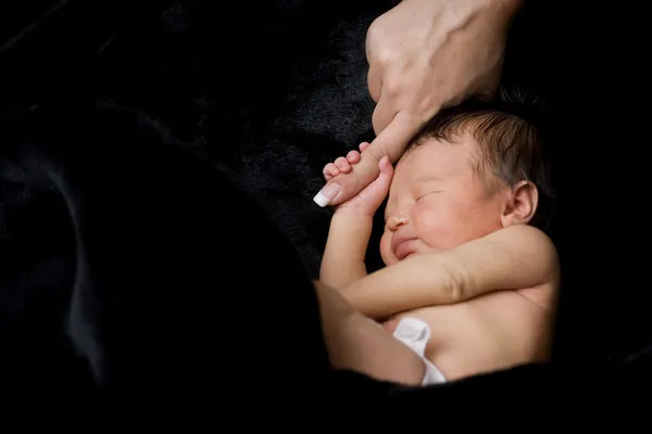 Newborn baby holding mother's finger — Stock Photo, Image