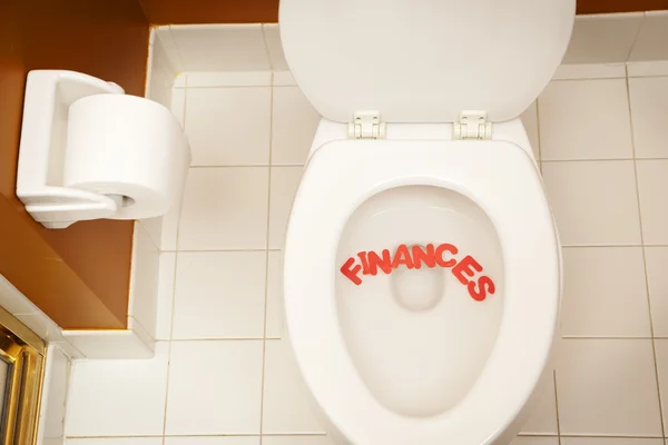 Bathroom toilet with the inscription finances — Stock Photo, Image