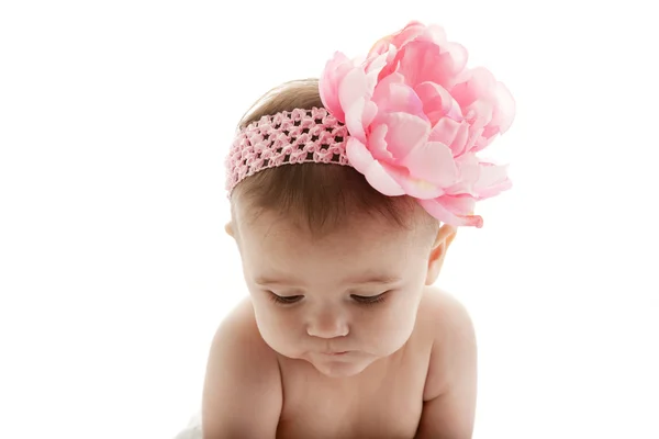 Doce menina usando uma faixa de cabeça com uma grande flor — Fotografia de Stock