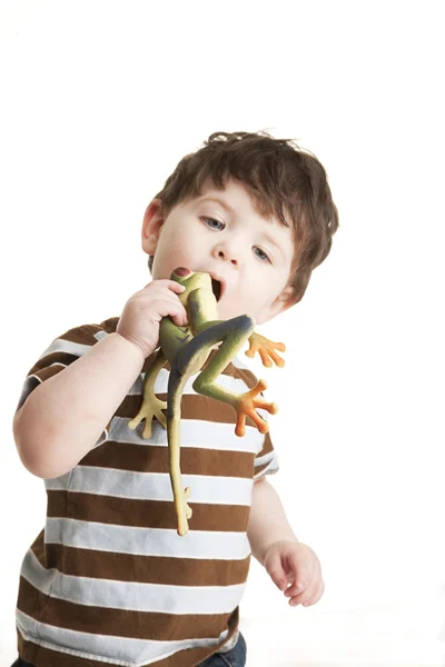 Niño fingiendo comer juguete de rana de plástico — Foto de Stock