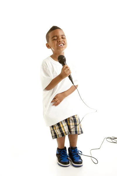छोटा लड़का एक माइक्रोफोन के साथ गा रहा है — स्टॉक फ़ोटो, इमेज