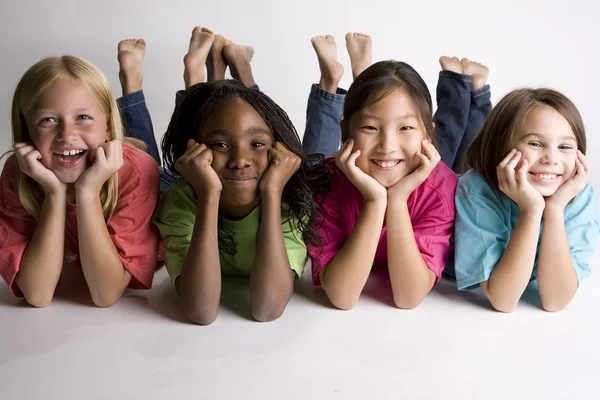 Chicas sonrientes tiradas en el suelo Imagen de archivo