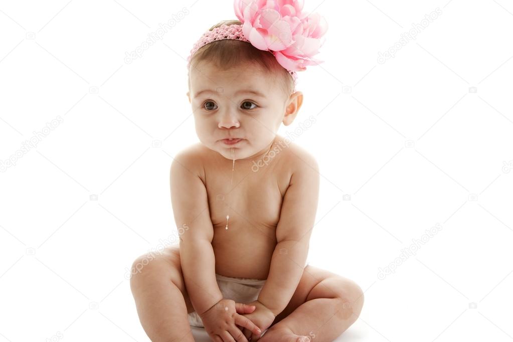 A cute baby girl sitting up and drooling