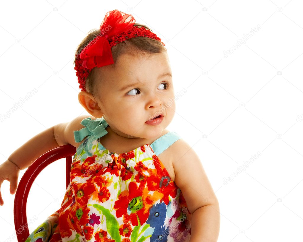 Pouting baby girl in colorful dress