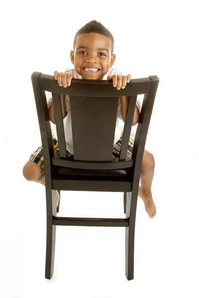 Счастливый африканский американский мальчик сидит на стуле — стоковое фото