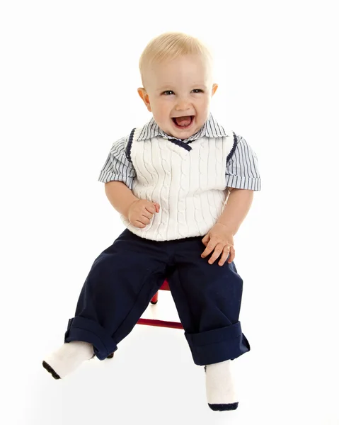 Lachende jongen zittend op een stoel — Stockfoto