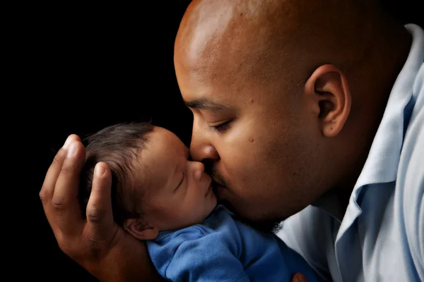 African american father cuddling and kissing his newborn son — Stock Photo, Image