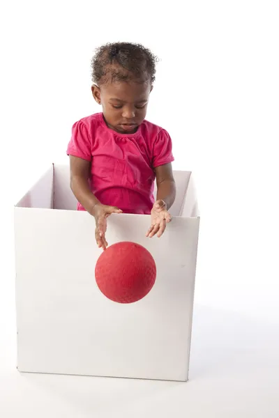 Bebé niña jugando en caja con pelota — Foto de Stock