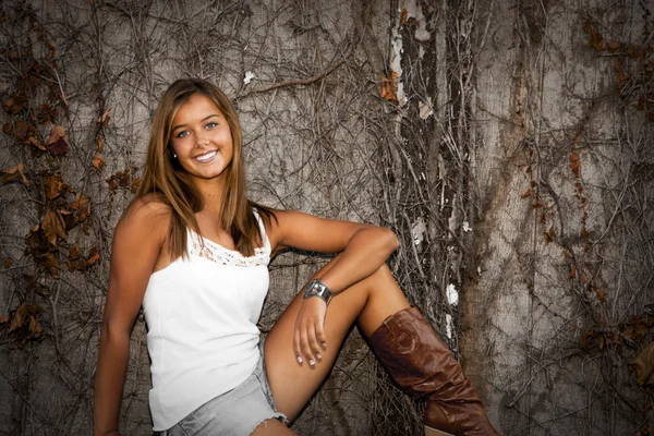 Menina adolescente bonita vestindo um corte calções jeans e botas de cowboy — Fotografia de Stock