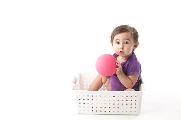 女の赤ちゃんの木枠に座っているとボール遊び — ストック写真