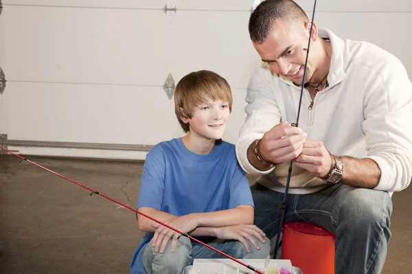 Jovem ajudando adolescente menino com equipamento de pesca — Fotografia de Stock