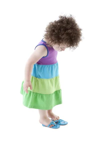 Razza mista bambino ragazza guardando giù al suo infradito scarpe — Foto Stock