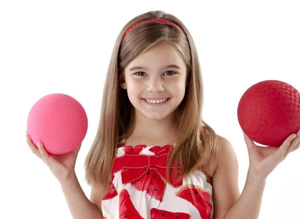 Adorable little girl balancing two playground balls — Stock Photo, Image