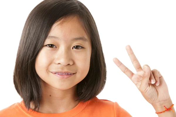 Asiatiska liten flicka ger ett peace-tecken — Stockfoto