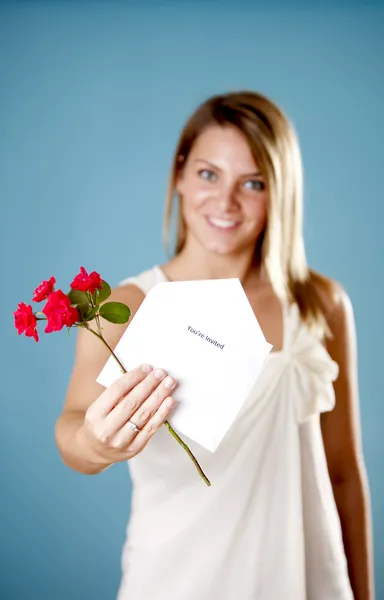 Mulher bonita segurando um convite e flores — Fotografia de Stock