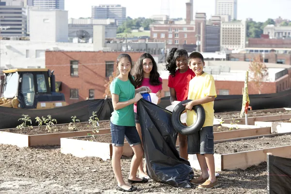 Grupo de niños de diferentes etnias recogiendo basura en un área urbana —  Fotos de Stock