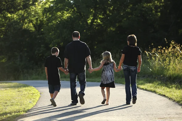 Full längd kaukasiska familjen promenader i parken — Stockfoto