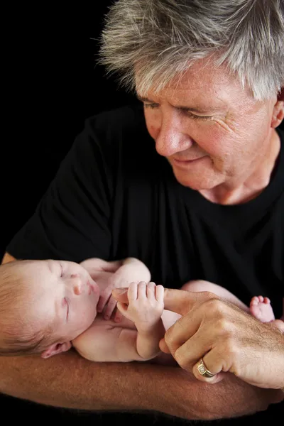 Großvater lächelt und hält Neugeborenes in der Hand — Stockfoto