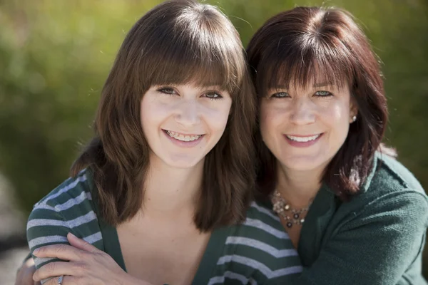 Smiling mother with her teenage daughter in the park — Stock Photo, Image