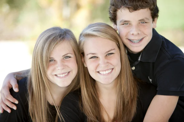 Image de trois frères et sœurs adolescents caucasiens souriants — Photo