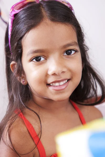 Mixed race little girl receiving a birthday gift — Stock Photo, Image