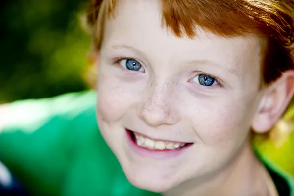 Портрет улыбающегося белого мальчика с рыжими волосами — стоковое фото