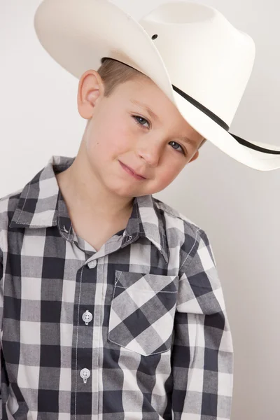 Lächelnder kleiner Junge mit Cowboyhut, kariertem Hemd und großer Gürtelschnalle — Stockfoto