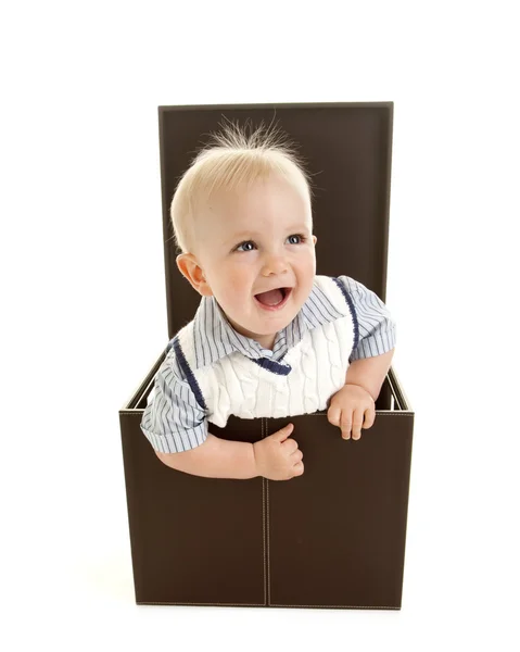 Smiling boy peeking out of a box Stock Image