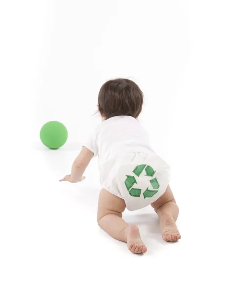 Bambino strisciando via dalla fotocamera e mostrando un simbolo di riciclaggio sul pannolino Immagini Stock Royalty Free