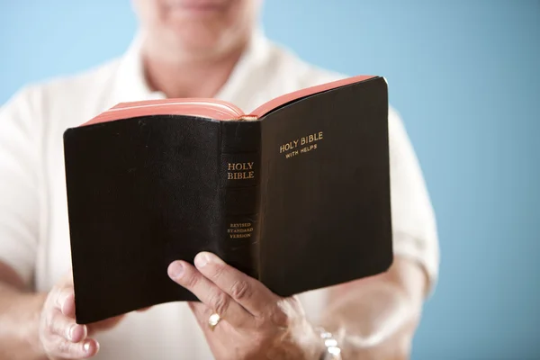 Kaukasische midden oude mens lezen van de Bijbel Stockfoto