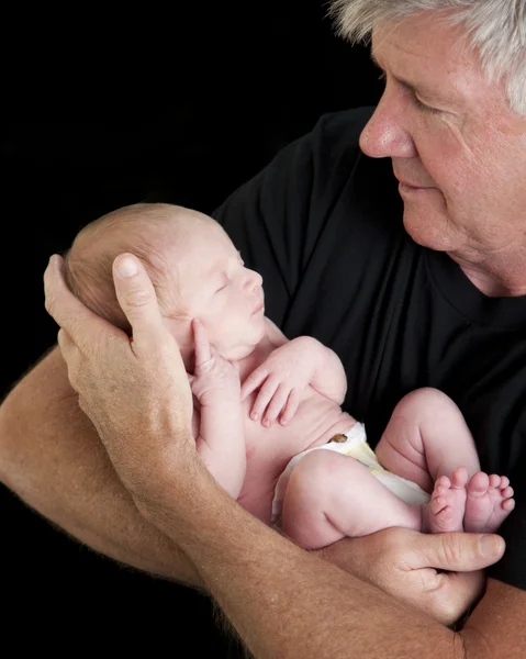 Grandfather holding newborn baby Stock Photo