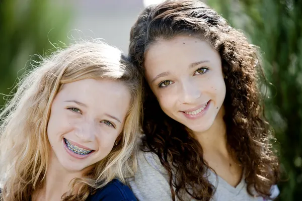 Dua gadis remaja Kaukasia tersenyum di taman Stok Foto Bebas Royalti