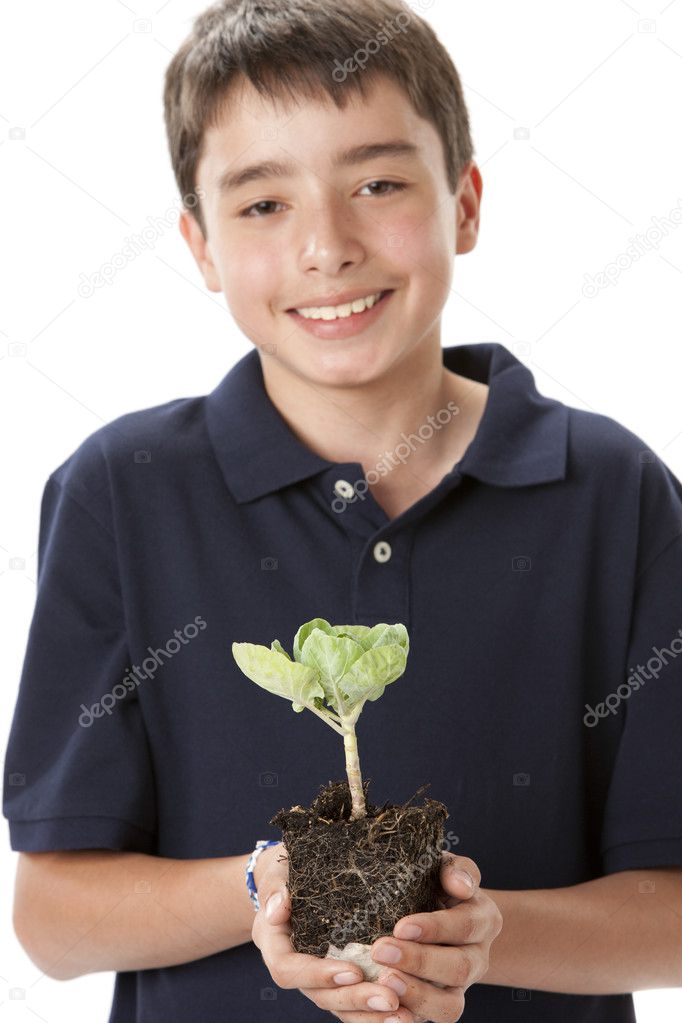Smiling teen boy holding green brussel sprout plant