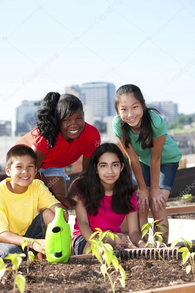 Group of children of different ethnicities working together to plant a garden