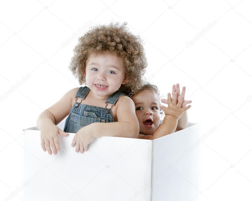 MIxed race toddler brother and sister jump out of box