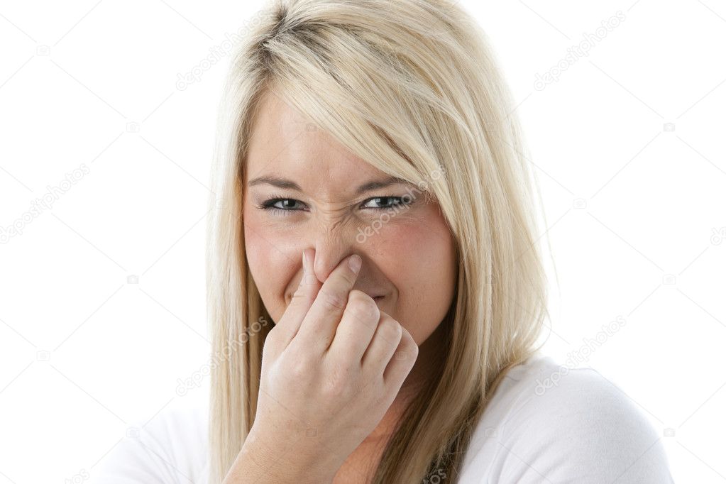 Caucasian young adult woman holding her nose as if she smells something bad