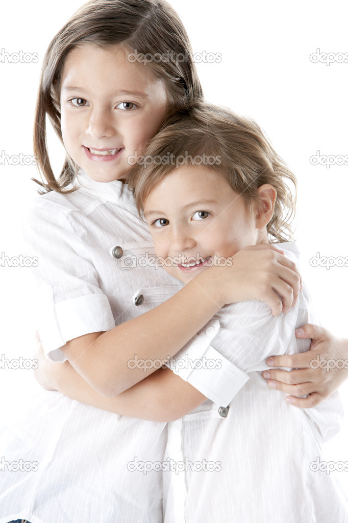 Waist up image of smiling little sisters embracing each other