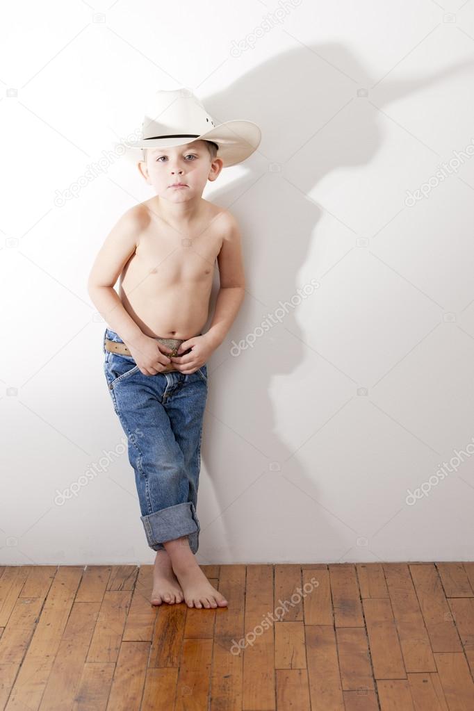 Full length image of caucasian little boy in cowboy hat and jeans