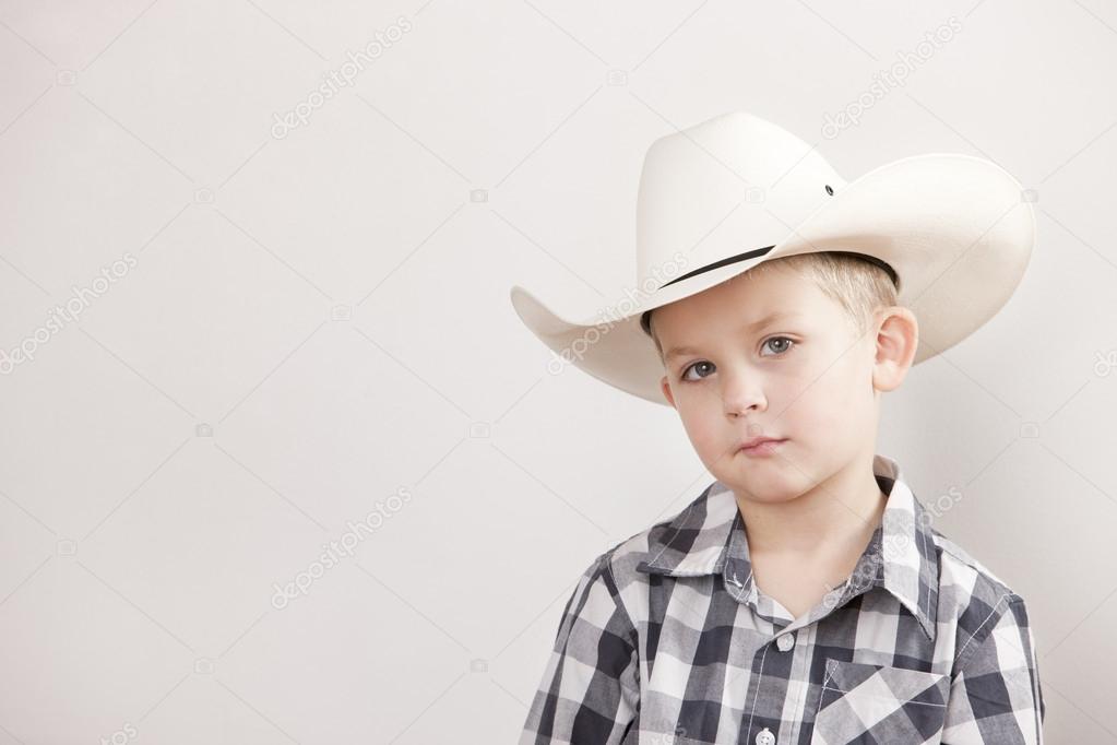 Serious little boy wearing a cowboy hat