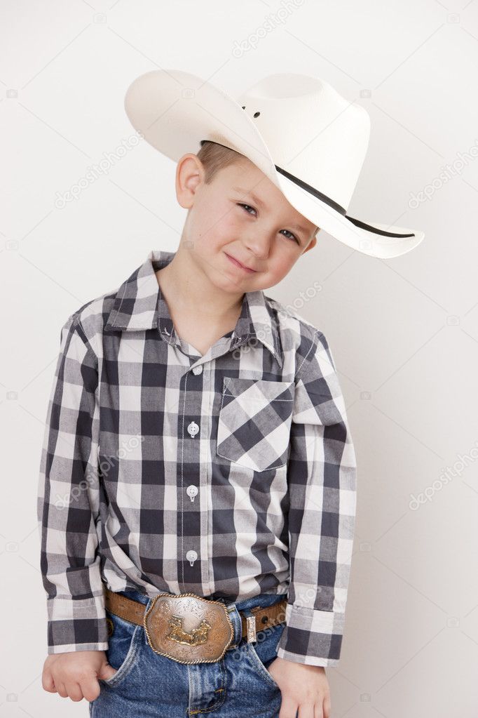 Waist up image of smiling little boy in cowboy hat, plaid shirt and a big belt buckle