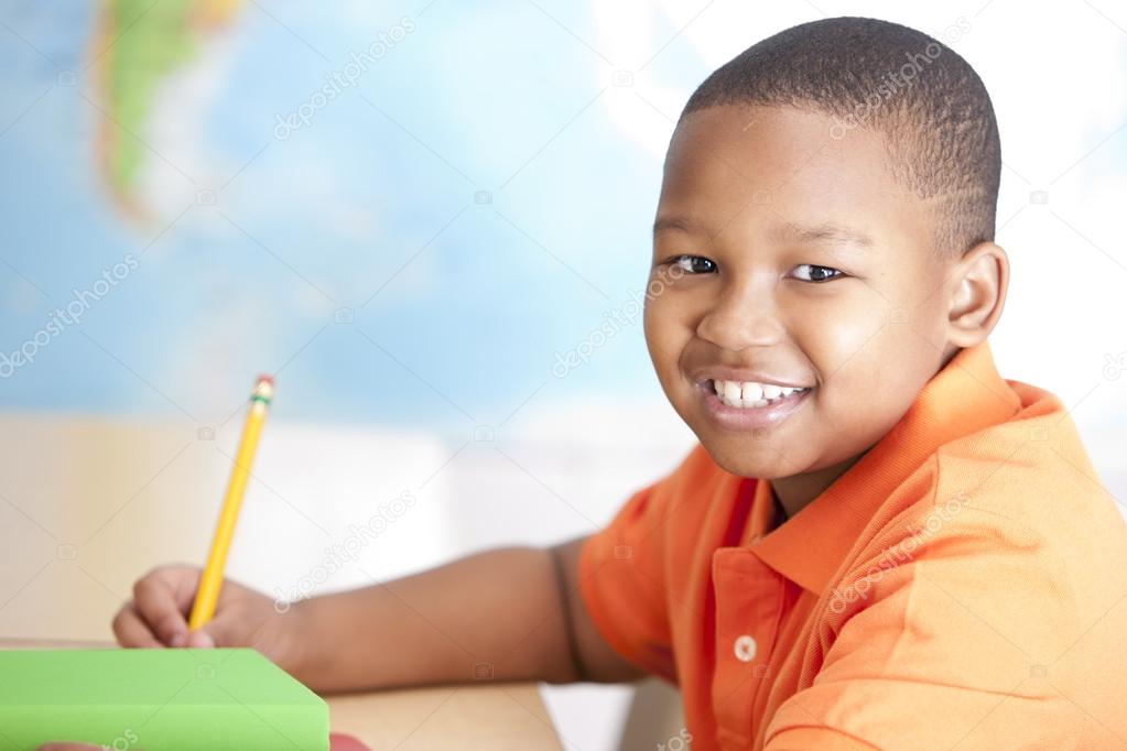 Image of african american little boy studying in school
