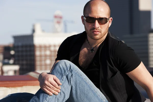 Real. Caucasian man sitting on a rooftop — Stock Photo, Image