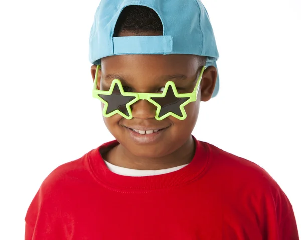 Real. Black little boy wearing a bright red shirt with a baseball cap and silly sunglasses — Stock Photo, Image