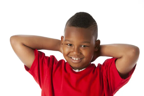 De verdad. Niño negro vistiendo una camisa roja brillante con las manos apoyadas detrás de la cabeza —  Fotos de Stock