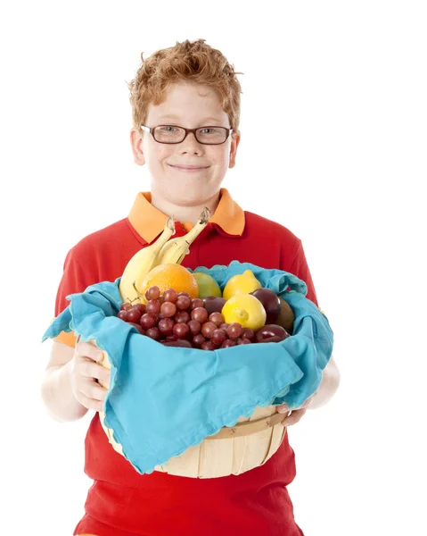 Gezond eten. Kaukasische kleine jongen met rood haar en glazen houden een mand gerangschikt met vers fruit — Stockfoto