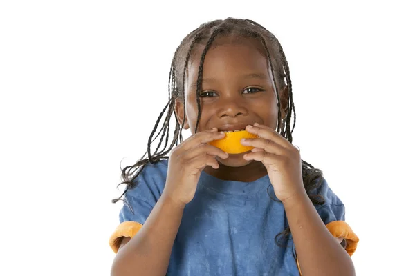 Az egészséges táplálkozás. Hogy egy boldog arc, egy narancs a szájában fekete kisfiú — Stock Fotó