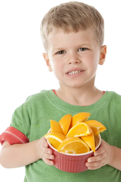 健康饮食。白人小男孩抱着一碗新鲜多汁的橙子 — 图库照片
