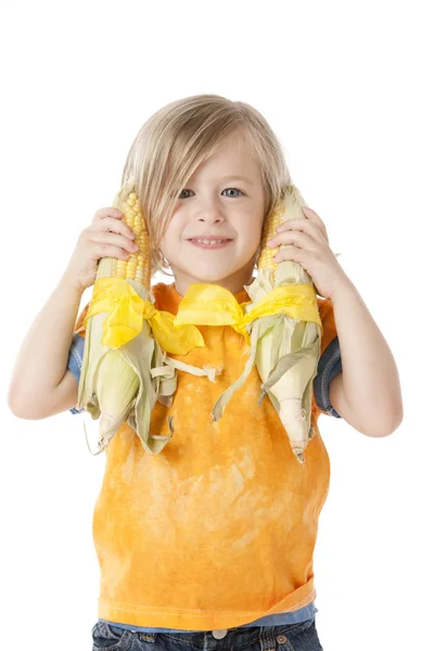 Gesunde Ernährung. Kaukasisches kleines Mädchen, das zwei Ähren bis zu den Ohren hält — Stockfoto