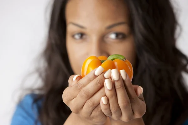 Healthy Eating. Black teenage girl holding out a bell pepper — Stock Photo, Image