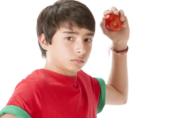 Gesunde Ernährung. Kaukasischer Teenager wirft eine Tomate — Stockfoto